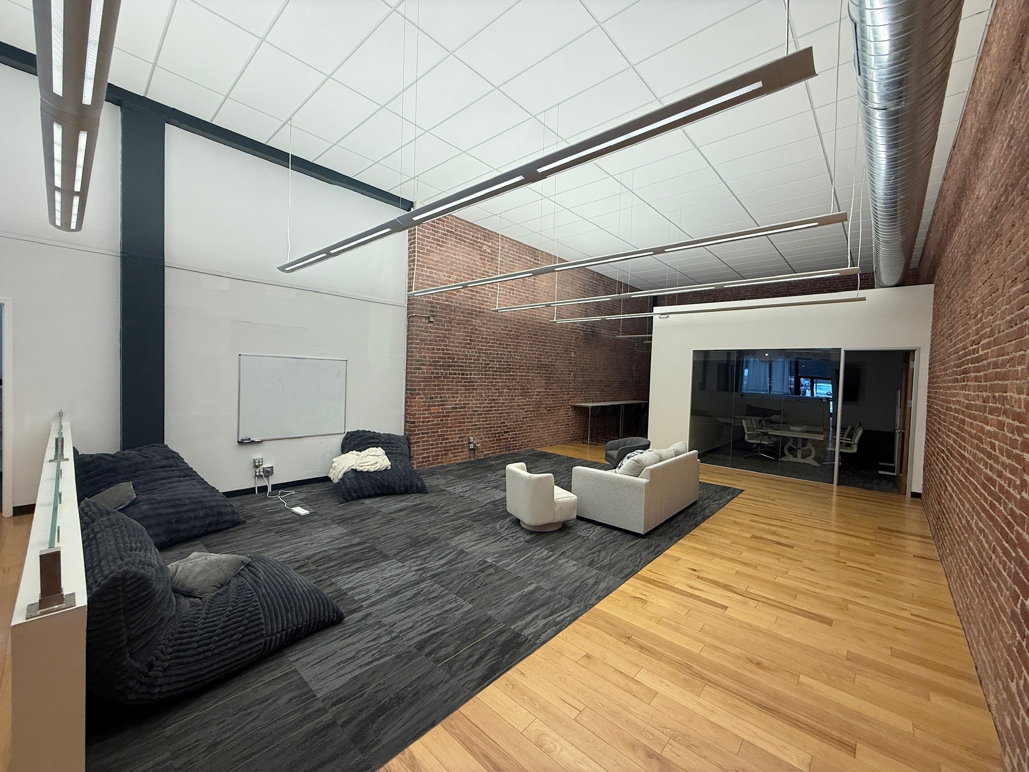 Exposed-brick lounge and glass conference room at ComputeCafe